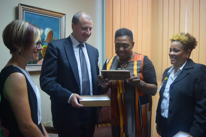 Minister of Culture, Gender, Entertainment and Sport, Honourable Olivia Grange, admires a wooden gift presented to her by (second left) Tom May, Deputy Director, NADO/RADO Relations of the World Anti-Doping Agency (WADA). Manager, Anti-Doping Initiatives, Karine Henrie (left) and (right) Permanent Secretary in the Ministry, Alison McLean also share in the moment.